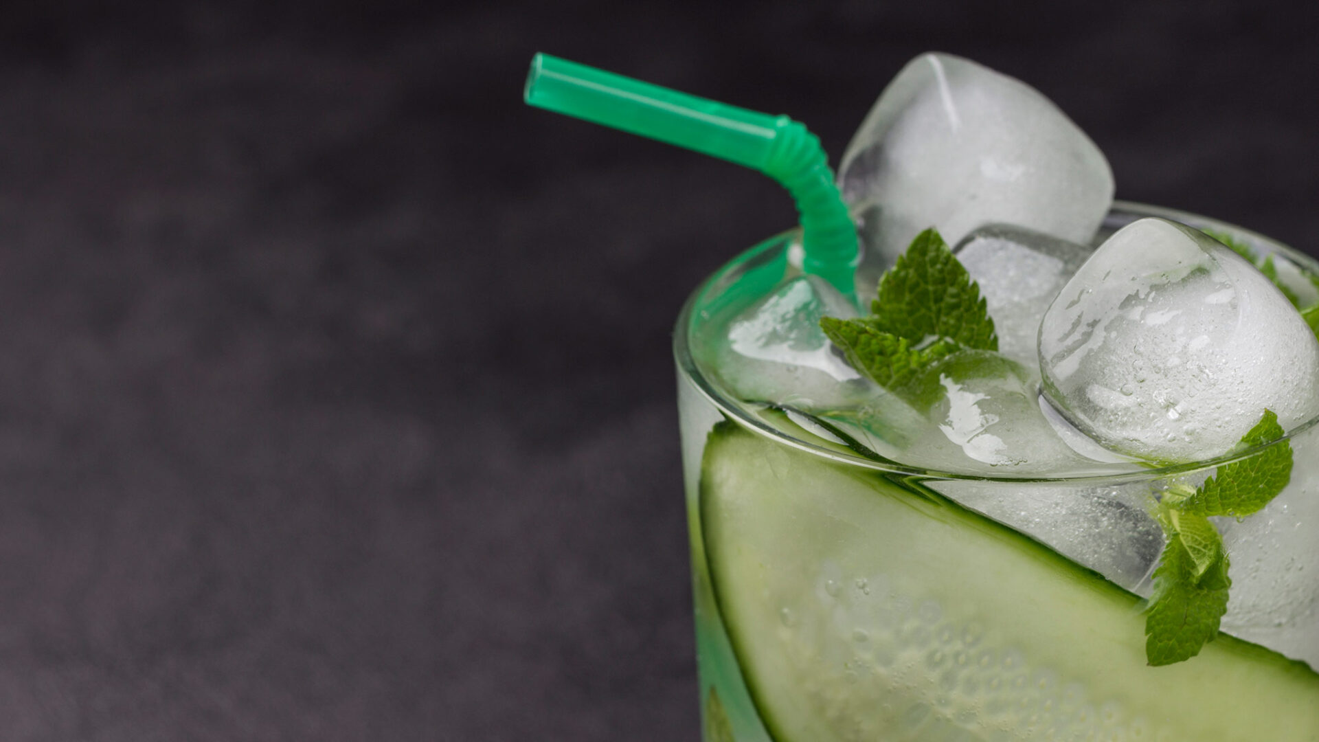 cooling summer drink with ice slices cucumber mint chopped cucumber black background copy space 16 9